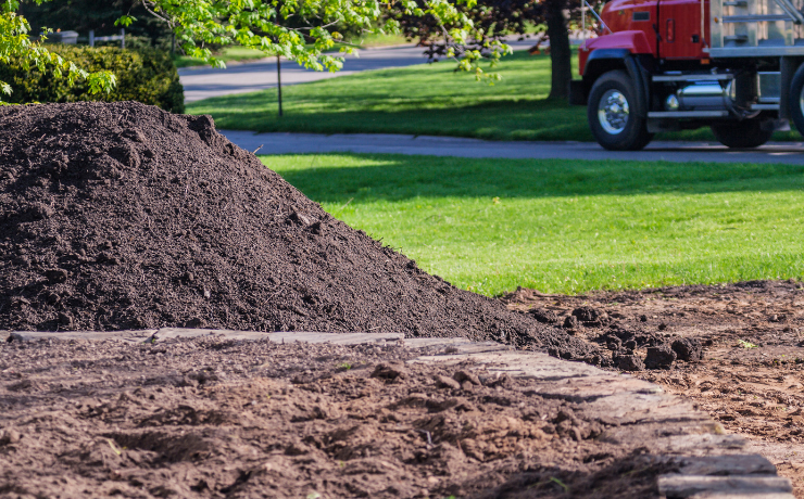 a pile of topsoil sits on a lawn without any grass before being re sodded