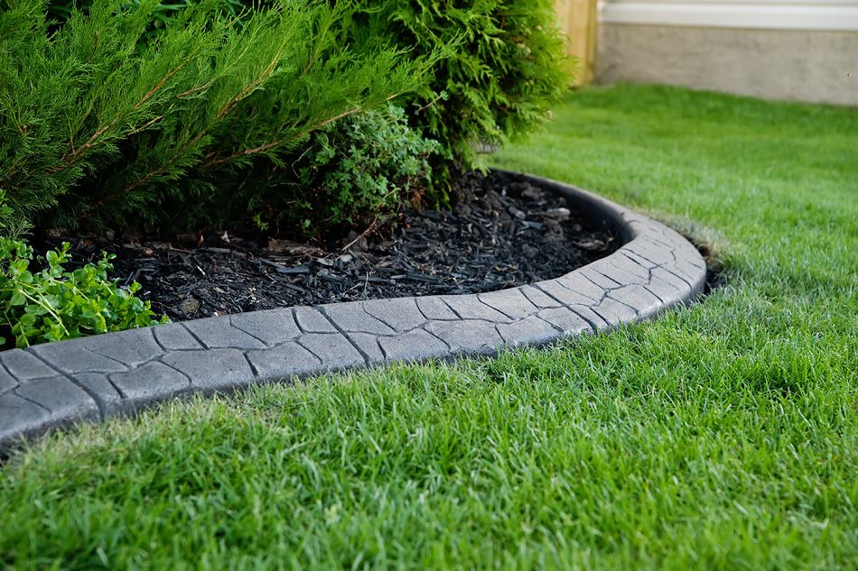 black concrete curbing separating garden from lawn