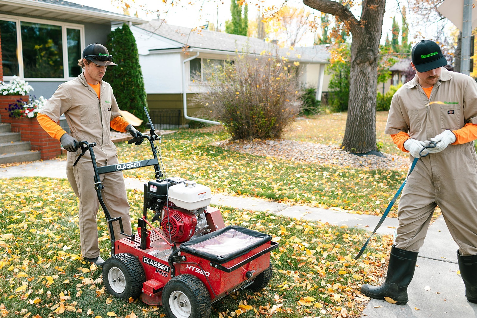 Local lawn care technicians performing mechanical aeration and soil inspection to improve overall turf health